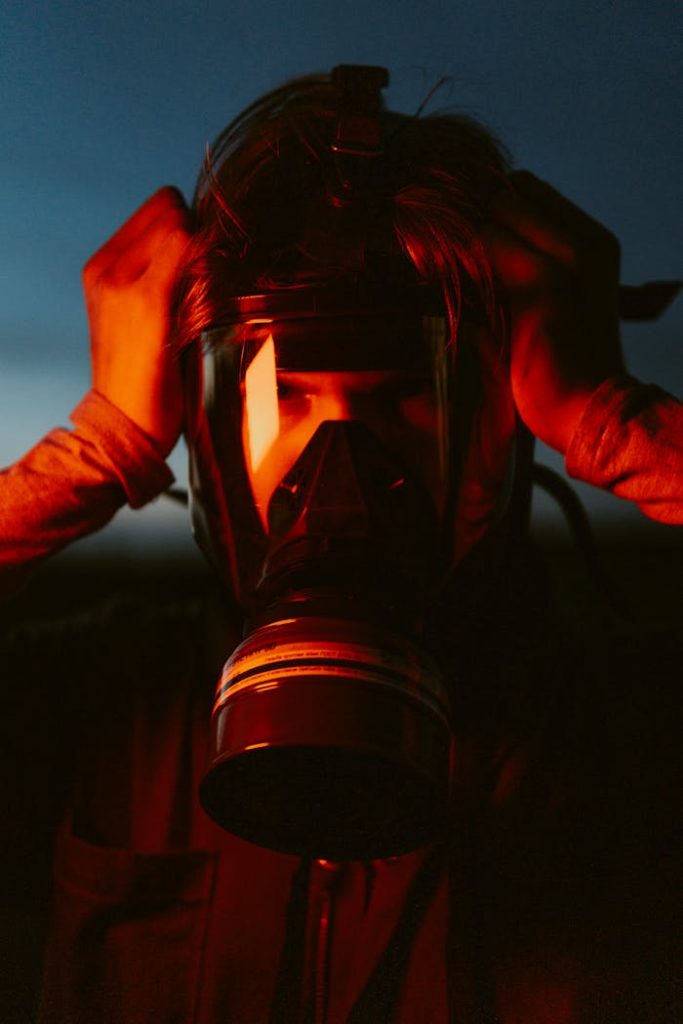 Crafting Captivating Headlines: Your awesome post title goes here Intense portrait of a person in a gas mask, illuminated by orange light, set against a dusky backdrop.